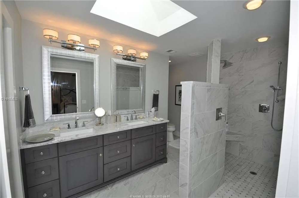 Bathroom remodel with double sink vanity, marble countertop and round mirrors by Burson Construction, Bluffton SC