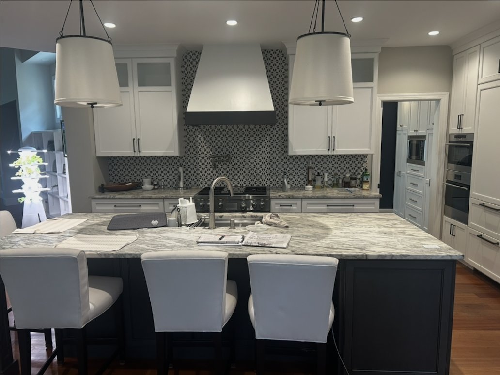Kitchen remodel with a large granite island, pendant lights, range hood and patterned tile backsplash by Burson Construction, Bluffton SC