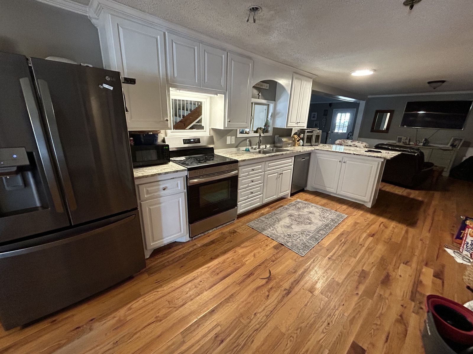 Remodeled kitchen with white cabinets, granite and hardwood floors by Burson Construction, Bluffton SC