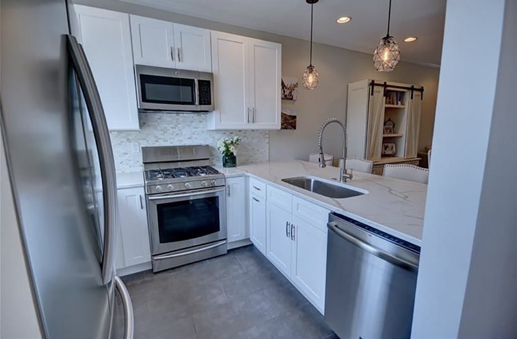 Kitchen remodel with white shaker cabinets, quartz countertops, pendant lights and stainless appliances by Burson Construction, Bluffton SC